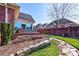 Backyard featuring a brick retaining wall, manicured landscaping, a hot tub, and a lush lawn at 105 Plantation Ct, Shelby, NC 28150