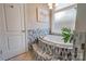 Soaking tub with gray tile surround, and adjacent frosted window provide an elegant and private bathroom space at 105 Plantation Ct, Shelby, NC 28150