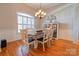 Bright dining room with hardwood floors, chandelier, wainscoting, and a classic dining set at 105 Plantation Ct, Shelby, NC 28150