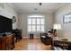 Cozy living room featuring hardwood floors, a comfortable leather chair, and plantation shutters at 105 Plantation Ct, Shelby, NC 28150