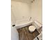 Well-lit bathroom featuring a white bathtub with a shower head and a matching toilet at 11433 Kingfisher Dr, Charlotte, NC 28226