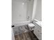 Clean bathroom with a white tub, toilet, and gray shag rug at 11433 Kingfisher Dr, Charlotte, NC 28226