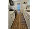 Galley kitchen with white cabinets, stainless steel appliances, and wood-look flooring at 11433 Kingfisher Dr, Charlotte, NC 28226