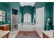 Bathroom with soaking tub, glass shower, and teal walls at 134 Wild Harbor Rd, Mooresville, NC 28117