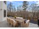 Outdoor patio area with a large dining table and views of the tree-lined backyard at 134 Wild Harbor Rd, Mooresville, NC 28117