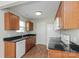 Galley kitchen with wood cabinets, granite counters, and white appliances at 152 Oliver St, York, SC 29745