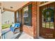 Close-up of a cozy front porch with a cushioned chair, brick accents, and decorative wreath at 162 Misty Woods Dr, Lake Wylie, SC 29710