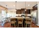 Modern kitchen featuring dark cabinetry, granite countertops, stainless steel appliances and a wooden breakfast bar with three chairs at 162 Misty Woods Dr, Lake Wylie, SC 29710