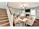 Inviting living room featuring hardwood floors, a fireplace, comfortable seating, a ceiling fan, and a staircase at 162 Misty Woods Dr, Lake Wylie, SC 29710