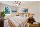 Virtually staged main bedroom with a light wood bed frame and large windows at 1721 Ameria Rd, Charlotte, NC 28215