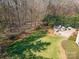 Aerial view of a lush backyard with a well-maintained lawn, mature trees, and a stone patio with fire pit at 1806 Grayscroft Dr, Waxhaw, NC 28173