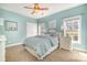 Serene bedroom featuring light blue walls, a ceiling fan, and two windows with views of the outdoors at 1806 Grayscroft Dr, Waxhaw, NC 28173