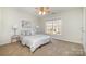 Cozy bedroom with neutral walls, ceiling fan, bedside tables, and a large window for natural light at 1806 Grayscroft Dr, Waxhaw, NC 28173