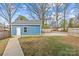 A blue backyard shed is surrounded by green grass and a concrete pathway at 2100 St Paul St, Charlotte, NC 28216