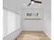 A light-filled bedroom with wood-look flooring, a shelf and a large window with blinds at 2100 St Paul St, Charlotte, NC 28216