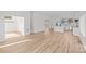 Bright, open-concept living space featuring wood-look flooring, a staircase and a modern kitchen in the background at 2100 St Paul St, Charlotte, NC 28216