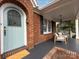 Charming light teal front door with arched window and brick surround at 2121 Winter St, Charlotte, NC 28205