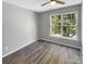 Well-lit bedroom with wood-look floors and ceiling fan at 2139 Mallard Green Pl, Charlotte, NC 28262