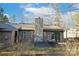 Backyard showing stone chimney, patio, outdoor furniture, and wooded surroundings at 2710 Redbud Ln, Fort Mill, SC 29715