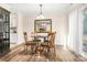 Bright dining room featuring a glass table, wood floors, and a decorative mirror at 2710 Redbud Ln, Fort Mill, SC 29715