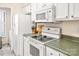 Cozy kitchen featuring white appliances and green countertops with a laundry area at 2710 Redbud Ln, Fort Mill, SC 29715