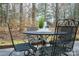 Cozy outdoor patio with a round table, metal chairs, and wooded views at 2710 Redbud Ln, Fort Mill, SC 29715