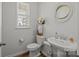 Modern powder room with pedestal sink, toilet, and decorative accents at 3089 Virginia Trail Ct, Fort Mill, SC 29715