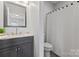 Bathroom featuring a modern vanity, mirror, and shower with white curtain and tiled floor at 309 Lloyd St, Salisbury, NC 28144