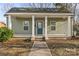 Charming home featuring a covered porch, blue front door and well maintained lawn at 309 Lloyd St, Salisbury, NC 28144