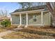 Charming home featuring a covered front porch with white columns, light-green siding, and a well-maintained lawn at 309 Lloyd St, Salisbury, NC 28144