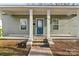 A charming front porch with sturdy white columns, light green siding and a welcoming entrance door at 309 Lloyd St, Salisbury, NC 28144