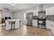 Kitchen featuring stainless steel appliances and white cabinets, with dining area and seating for four visible at 309 Lloyd St, Salisbury, NC 28144