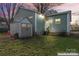 Back of home featuring light-green siding, a convenient shed for storage, and a well-maintained lawn at 309 Lloyd St, Salisbury, NC 28144