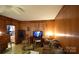 Living room with wood paneling, vintage furniture, and TV at 315 S Hill St, Gastonia, NC 28052