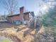 Rustic exterior of a multi-level home featuring wood siding, brick chimney and a wooden deck with stairs at 3609 Shillinglaw Rd, Sharon, SC 29742