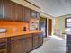 Kitchen featuring wood cabinets, orange countertops, and a breakfast bar adjoining the laundry room at 3609 Shillinglaw Rd, Sharon, SC 29742