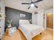 A modern main bedroom featuring a ceiling fan, wood floors, white paneled walls and a decorative dark accent wall at 3609 Shillinglaw Rd, Sharon, SC 29742