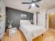 A modern main bedroom featuring a ceiling fan, wood floors, white paneled walls and a decorative dark accent wall at 3609 Shillinglaw Rd, Sharon, SC 29742