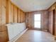 Unfinished room with plywood walls, hardwood floors, a bright window, and construction materials inside at 3609 Shillinglaw Rd, Sharon, SC 29742