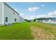 Home's backyard with green grass, some bare patches and a view of the neighborhood at 3915 Allenby Pl, Monroe, NC 28110