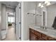 Neutral bathroom with marble countertop, dark wood vanity, and an entrance to the adjacent bedroom at 4008 Quintessa Dr, Matthews, NC 28104