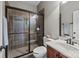 Bathroom featuring a tiled walk-in shower with glass doors, a vanity with white sink and dark wood cabinets at 4008 Quintessa Dr, Matthews, NC 28104