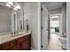 Neutral bathroom features a wood vanity with marble counters and an entrance to the adjacent bedroom at 4008 Quintessa Dr, Matthews, NC 28104