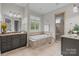 This bathroom boasts double vanities, a soaking tub, and a glass-enclosed shower for a luxurious spa-like experience at 4008 Quintessa Dr, Matthews, NC 28104