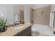 Bathroom featuring granite counters, dark cabinets, and a tiled shower-tub, offering both style and functionality at 4008 Quintessa Dr, Matthews, NC 28104