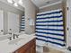 Bathroom featuring a shower with blue and white striped curtain and neutral counters and cabinets at 4008 Quintessa Dr, Matthews, NC 28104