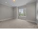 Bright, carpeted bedroom with a large window, base molding, and recessed lighting, offering a cozy atmosphere at 4008 Quintessa Dr, Matthews, NC 28104