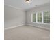 Bedroom features neutral carpet, crown molding, and a large window with view at 4008 Quintessa Dr, Matthews, NC 28104