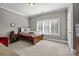 Neutral bedroom featuring a bed with neutral bedding, carpeted floors, and a large window for natural light at 4008 Quintessa Dr, Matthews, NC 28104