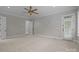 This large bedroom features neutral walls and carpet, a ceiling fan, and a door to the outside at 4008 Quintessa Dr, Matthews, NC 28104